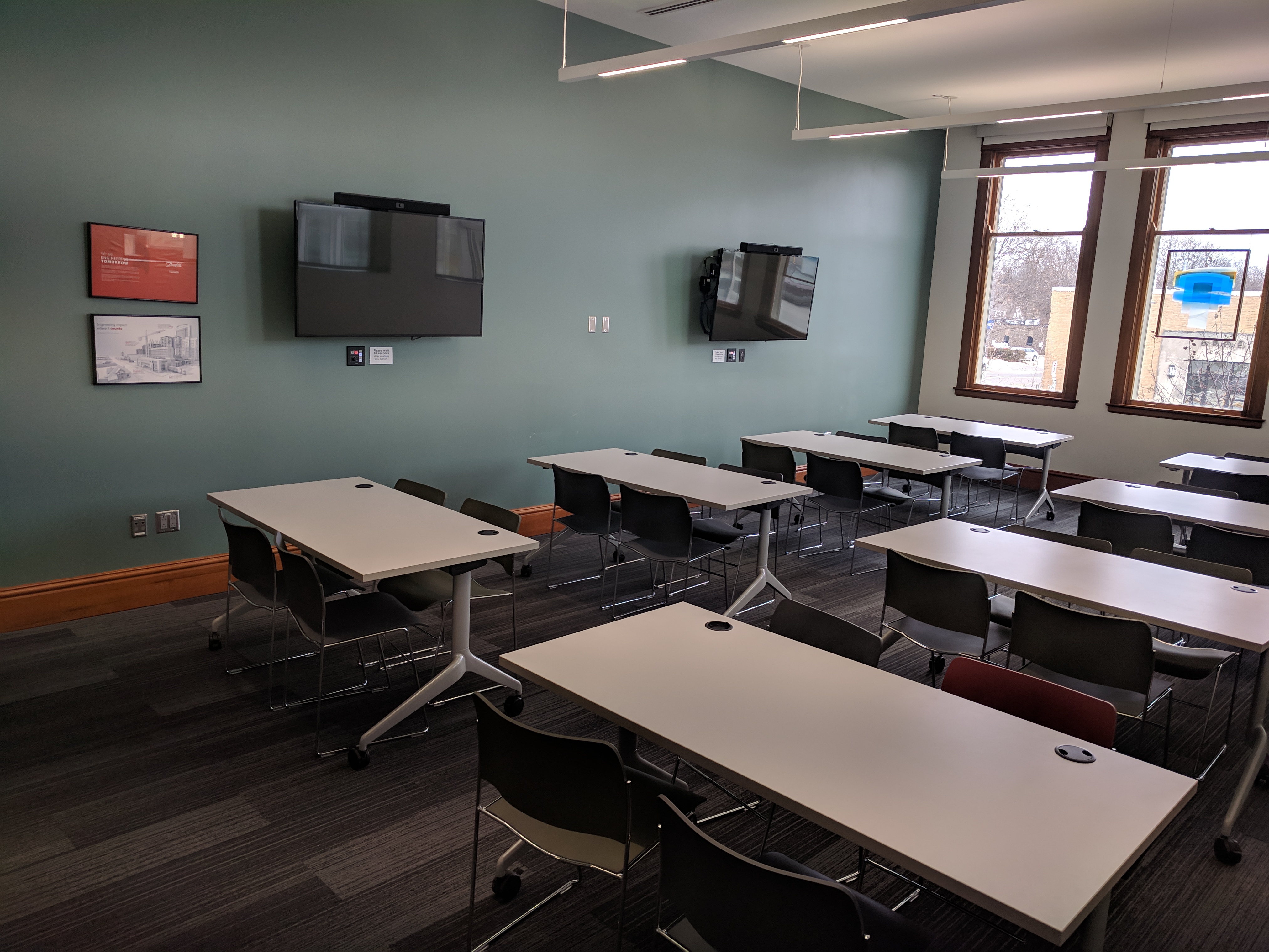 Danfoss Room with classroom style room setup and two mounted screens