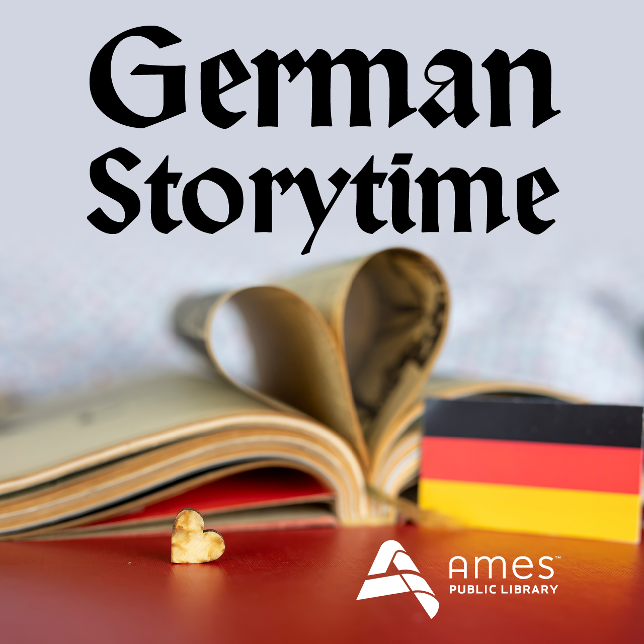 German Storytime. Image features small German flag, heart pin, and book with pages curved into a heart shape.