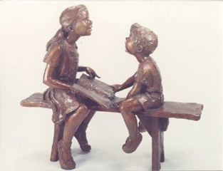 Cast bronze statue of girl and boy reading a book 