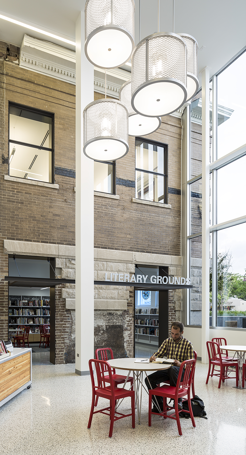 "Person reading at table next to the Literary Grounds Bookstore"