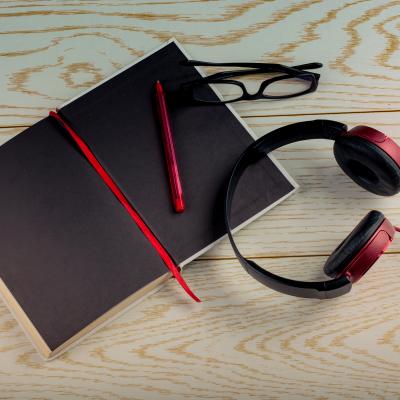 Book with headphones, glasses, and pen