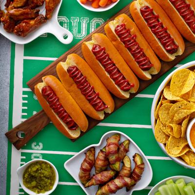 Photo of hot dogs and other food on a table made to look like a football field