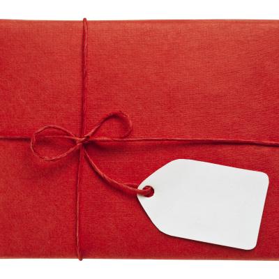 Photo of a gift wrapped in red paper and string with a gift tag
