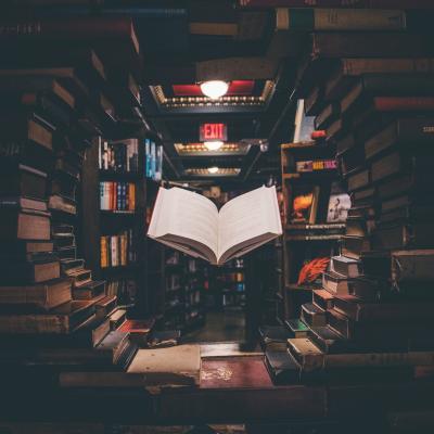 Image of a book floating in a dark library filled with books