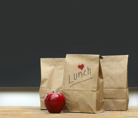 Photo of lunch bags with an apple and chalkboard