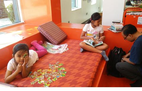 Family Reads Books and Plays with Puzzles at Ames Public Library