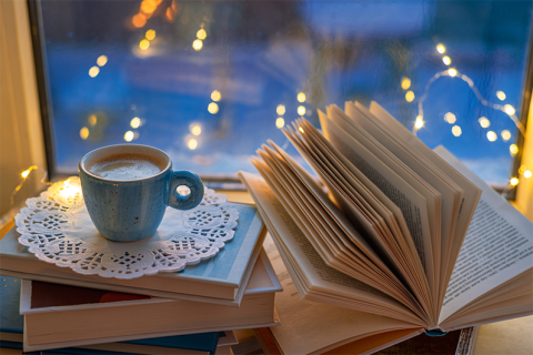 Mug and book next to a sparkly window
