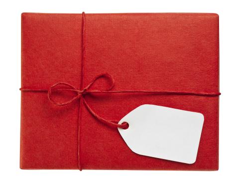 Photo of a gift wrapped in red paper and string with a gift tag
